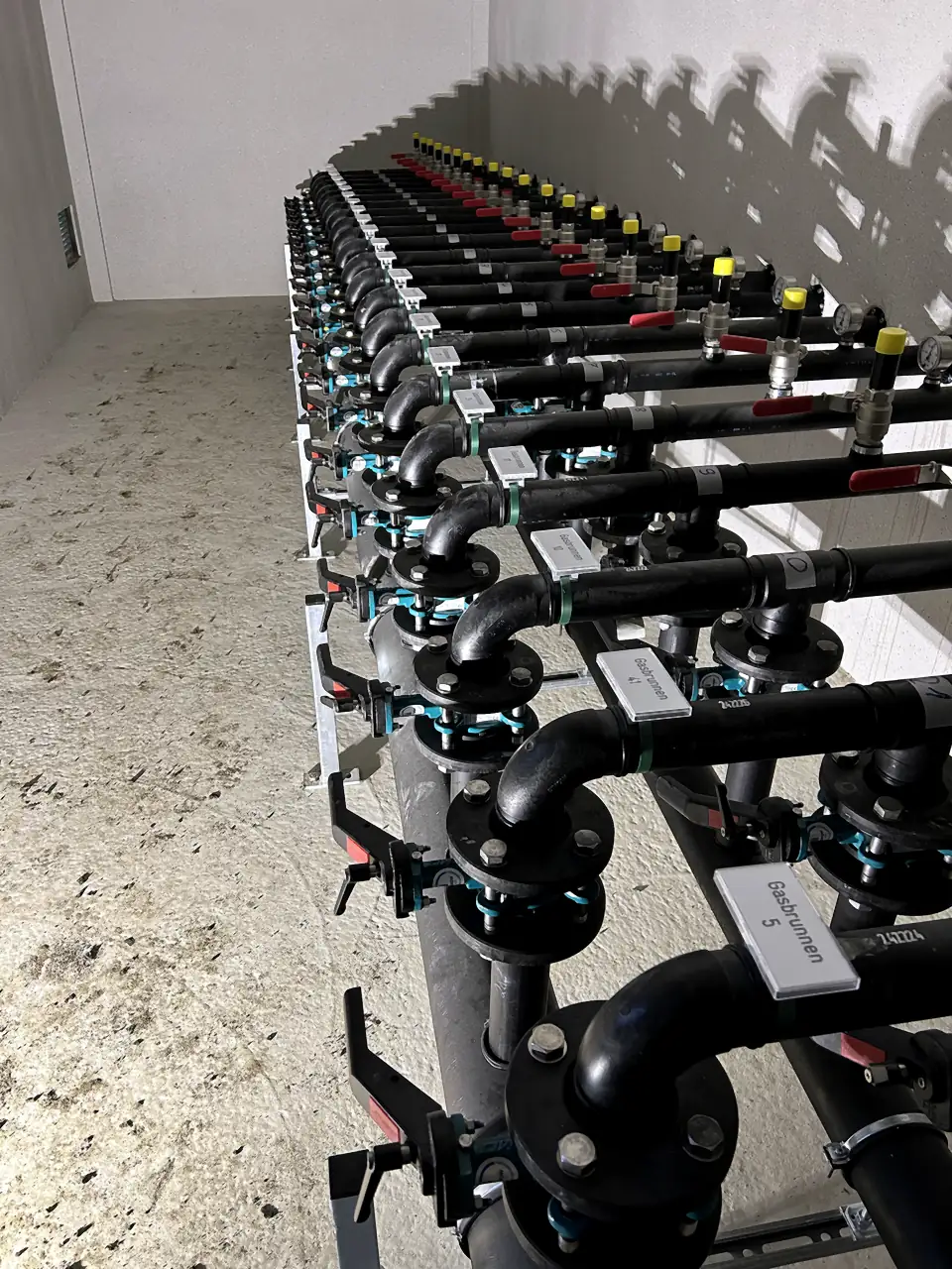 PE pipe manifold with valves and fittings by a wall