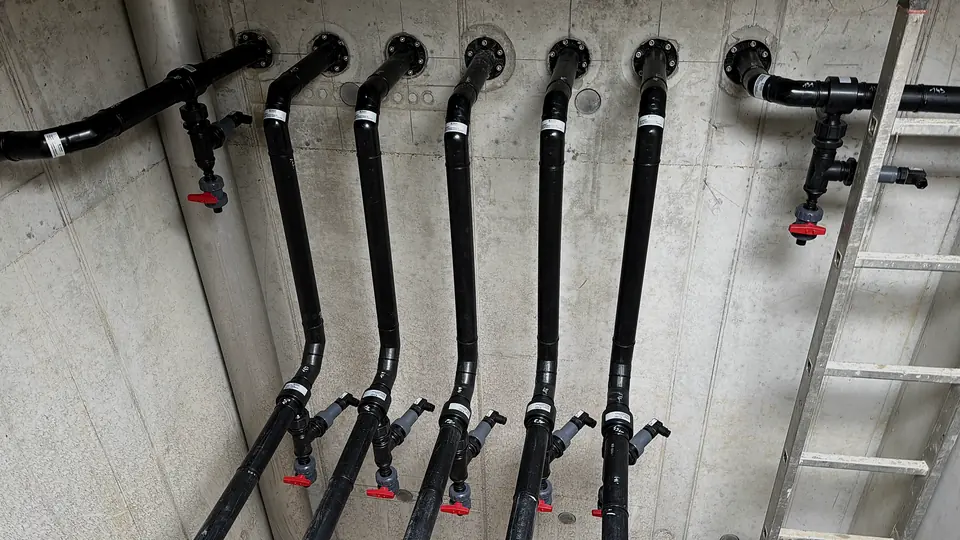 Vertical PE pipe outlets next to a wall