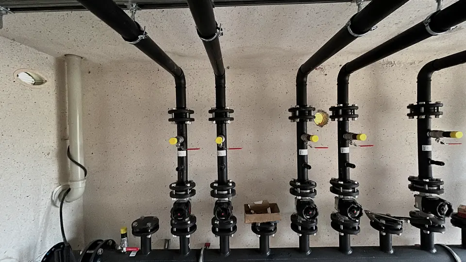 Vertical pipes with valves and fittings by a wall