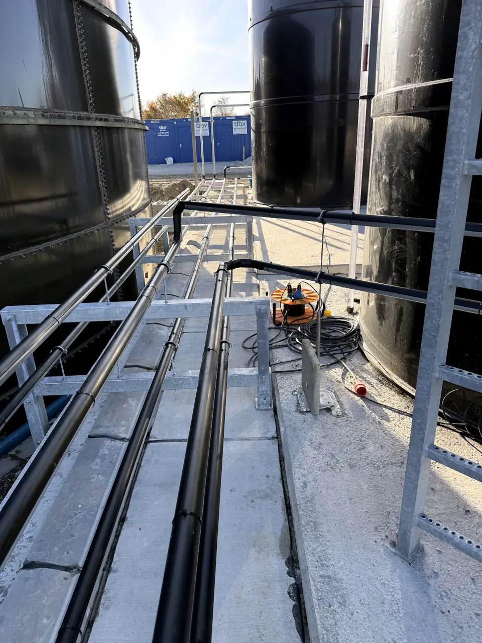 Pipelines routed along a tank on a pipe bridge